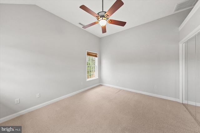 unfurnished room with ceiling fan, visible vents, vaulted ceiling, and light colored carpet