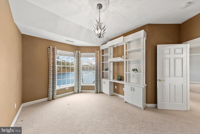 unfurnished bedroom with vaulted ceiling, an inviting chandelier, baseboards, visible vents, and light carpet