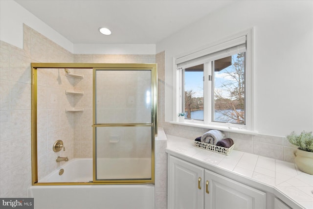 bathroom with combined bath / shower with glass door
