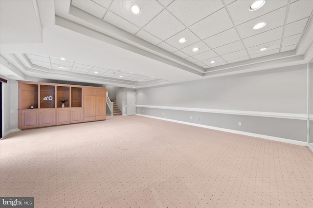 below grade area with light carpet, baseboards, and stairs