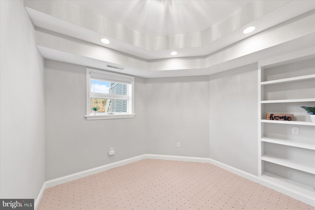 carpeted empty room with baseboards, built in shelves, visible vents, and recessed lighting