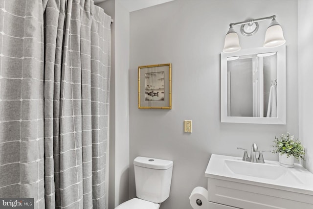 bathroom featuring toilet, a shower with shower curtain, and vanity