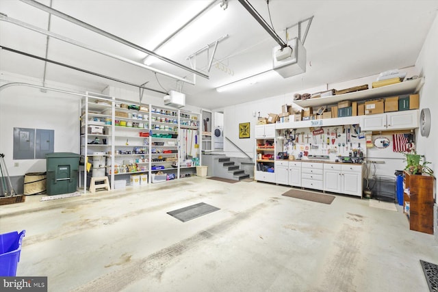 garage with electric panel, a garage door opener, and a workshop area