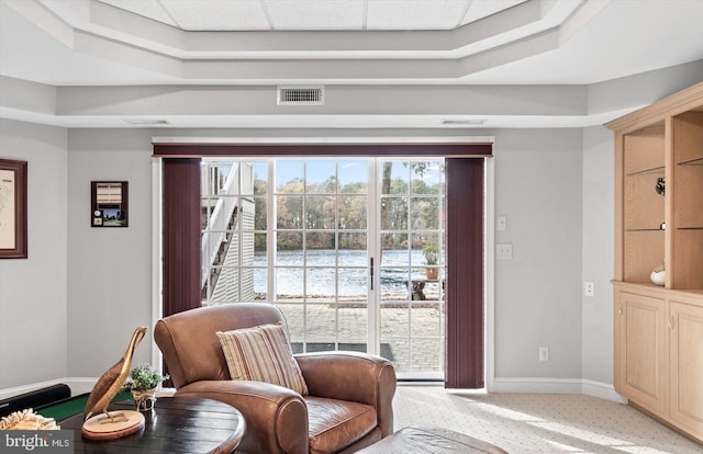 sitting room featuring baseboards, visible vents, and light colored carpet