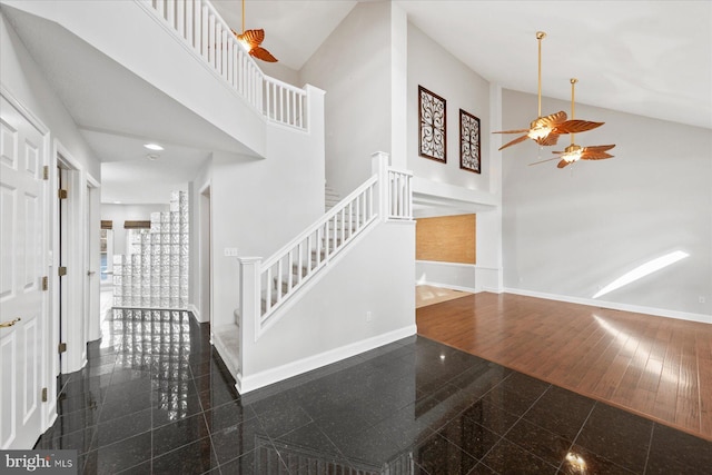 entryway with stairs, high vaulted ceiling, baseboards, granite finish floor, and ceiling fan