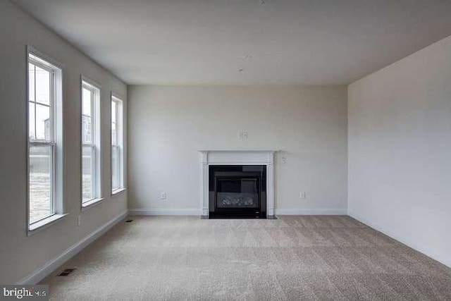 unfurnished living room featuring light colored carpet