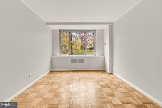 empty room featuring crown molding and light parquet flooring