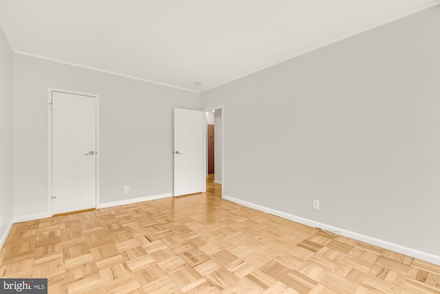 spare room with ornamental molding and light parquet flooring