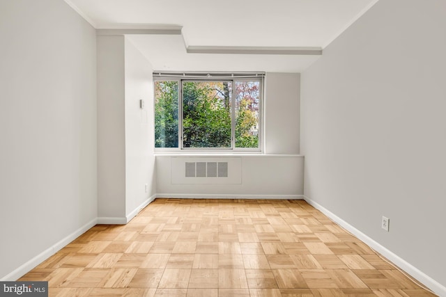 spare room featuring light parquet flooring and ornamental molding