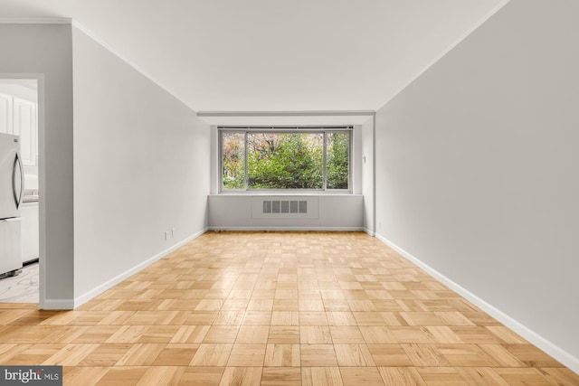 empty room featuring ornamental molding and light parquet flooring