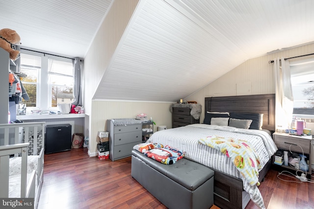 bedroom featuring wooden walls, dark hardwood / wood-style floors, and lofted ceiling