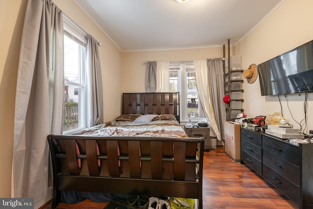 bedroom featuring multiple windows, crown molding, and dark wood-type flooring