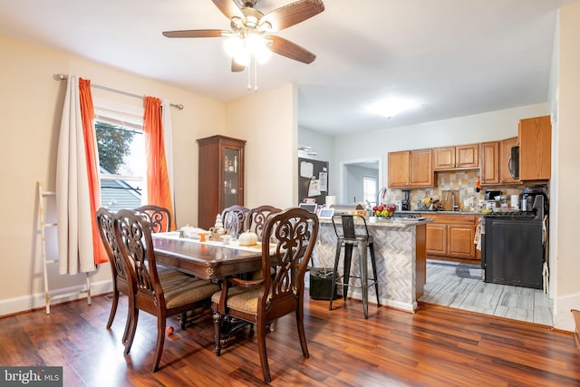 dining area featuring ceiling fan and dark wood-type flooring