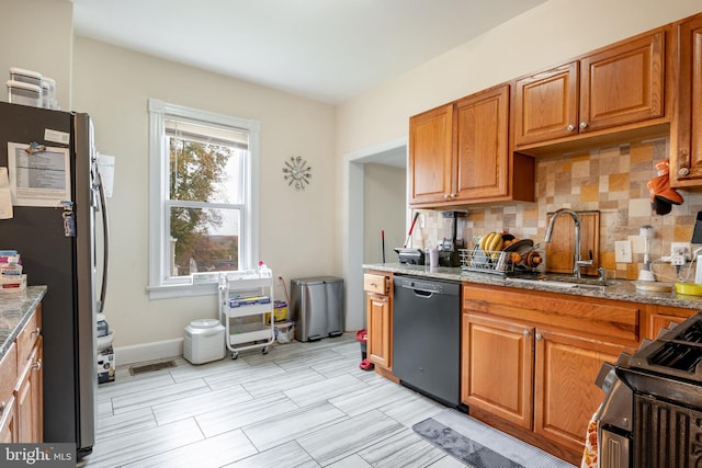 kitchen with decorative backsplash, stainless steel fridge, stove, sink, and black dishwasher