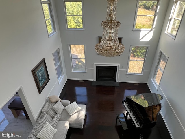 living room with dark hardwood / wood-style flooring and a towering ceiling