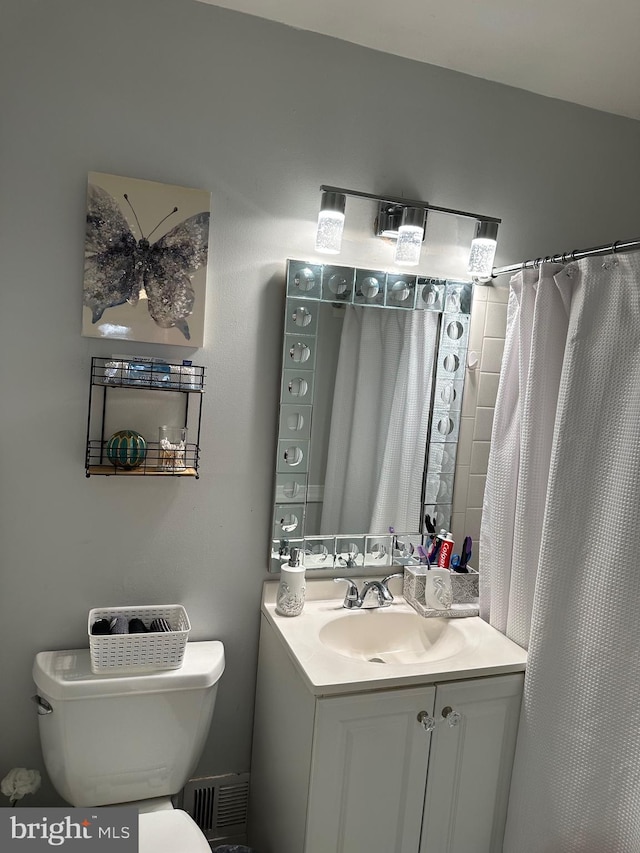 bathroom featuring vanity, a shower with shower curtain, and toilet