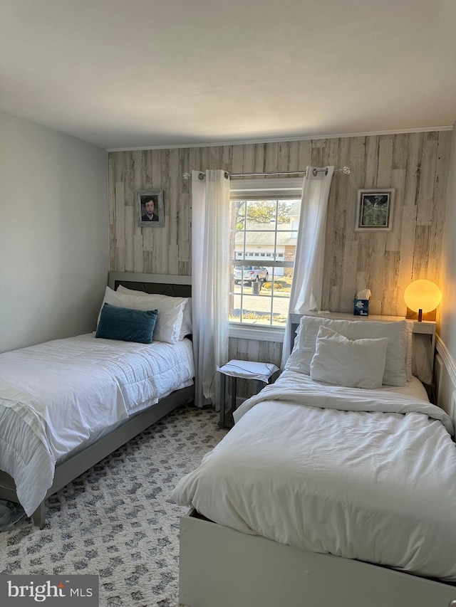 carpeted bedroom featuring wooden walls