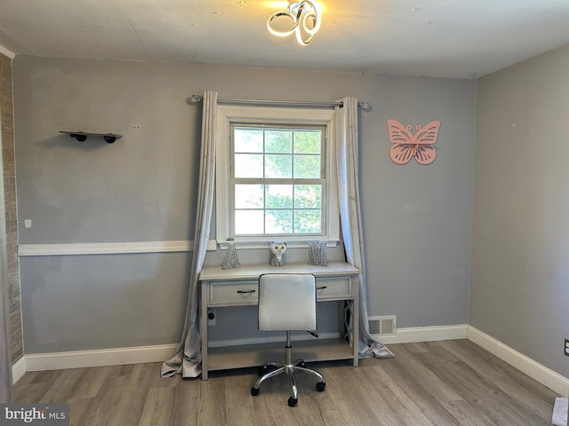 home office with light hardwood / wood-style flooring