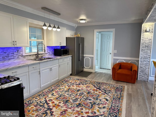 kitchen with light hardwood / wood-style flooring, stainless steel appliances, white cabinetry, and sink