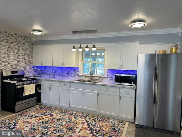 kitchen featuring stainless steel appliances, white cabinetry, and sink