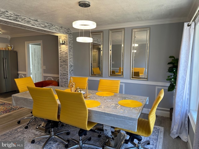 dining room with a textured ceiling, dark hardwood / wood-style floors, and crown molding