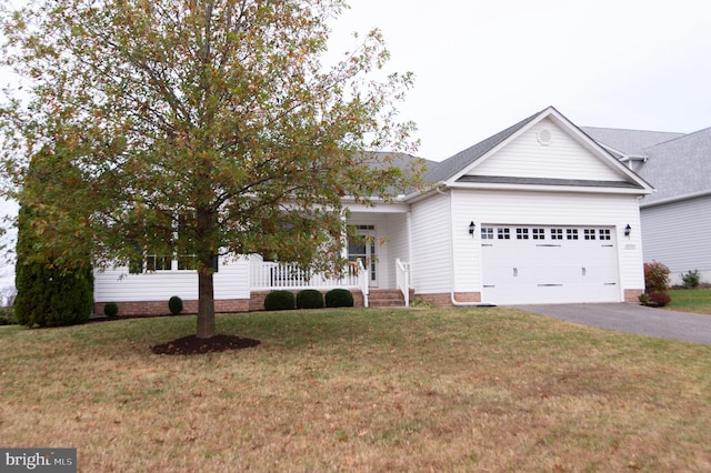 view of front of property featuring a porch, a garage, and a front yard