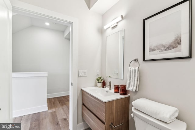 bathroom with hardwood / wood-style flooring, vanity, and toilet