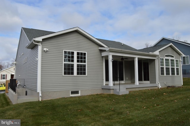 back of property with ceiling fan, a yard, and a patio area