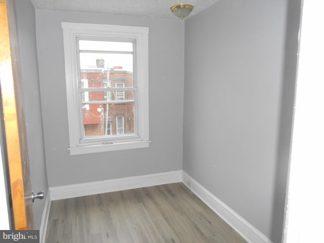 unfurnished room with a textured ceiling and hardwood / wood-style flooring