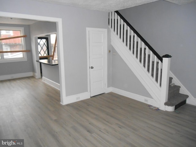 stairs featuring a textured ceiling and hardwood / wood-style flooring