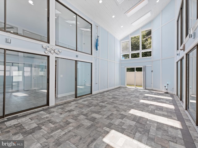 empty room with a skylight and high vaulted ceiling