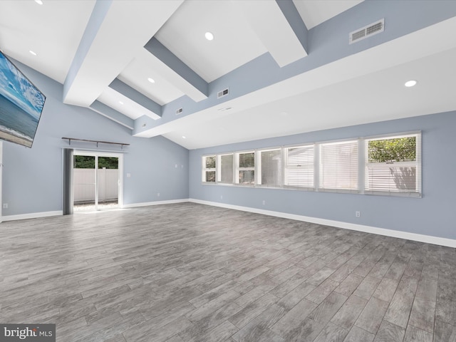 unfurnished room featuring wood-type flooring and vaulted ceiling with beams