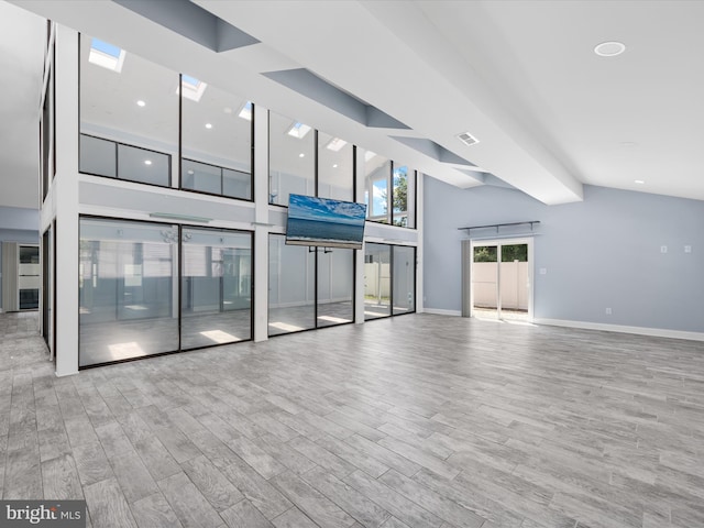 unfurnished living room with vaulted ceiling and light hardwood / wood-style flooring