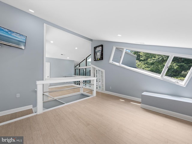 additional living space featuring light hardwood / wood-style floors and lofted ceiling