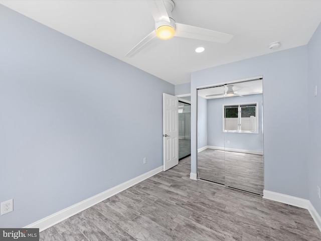 unfurnished bedroom with hardwood / wood-style floors, a closet, and ceiling fan