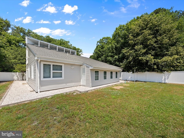 rear view of property featuring a lawn