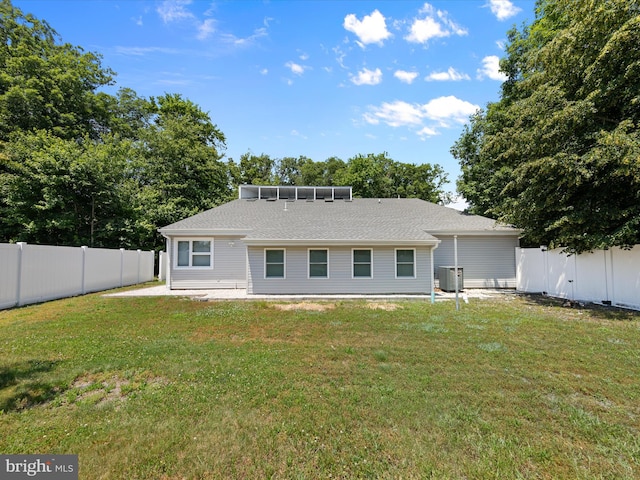 back of house featuring a lawn and central air condition unit