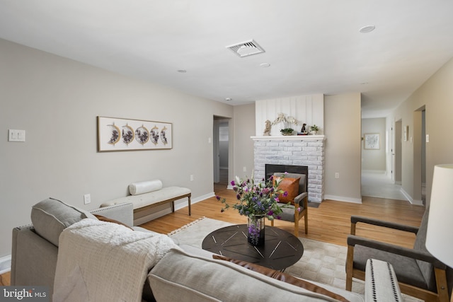 living room featuring a fireplace and light wood-type flooring