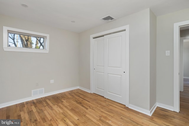 unfurnished bedroom with a closet and light wood-type flooring