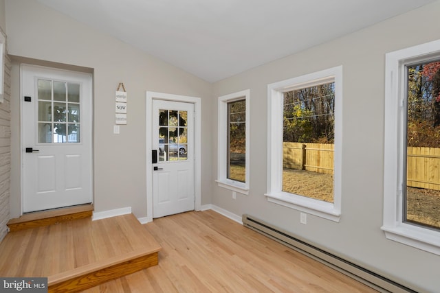 entryway with baseboard heating, lofted ceiling, and light wood-type flooring