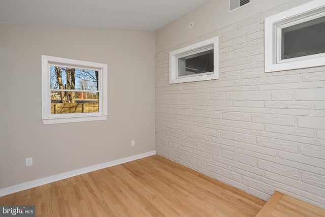 spare room featuring lofted ceiling and light wood-type flooring