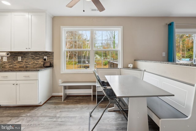 dining space featuring light wood-type flooring, ceiling fan, and a healthy amount of sunlight