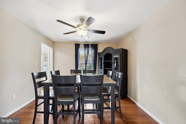 dining space with ceiling fan and dark hardwood / wood-style flooring