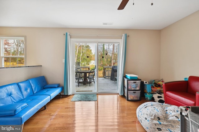 living room with a wealth of natural light, ceiling fan, and light hardwood / wood-style floors