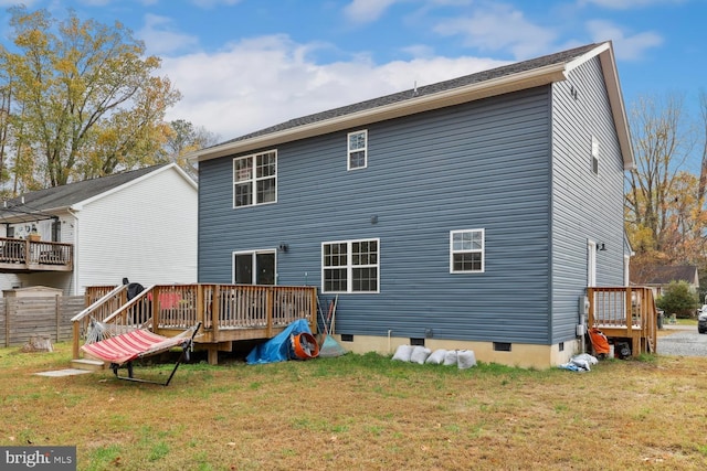 rear view of property featuring a deck and a lawn