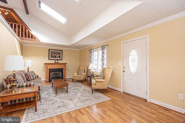 living room with crown molding, light hardwood / wood-style flooring, and vaulted ceiling