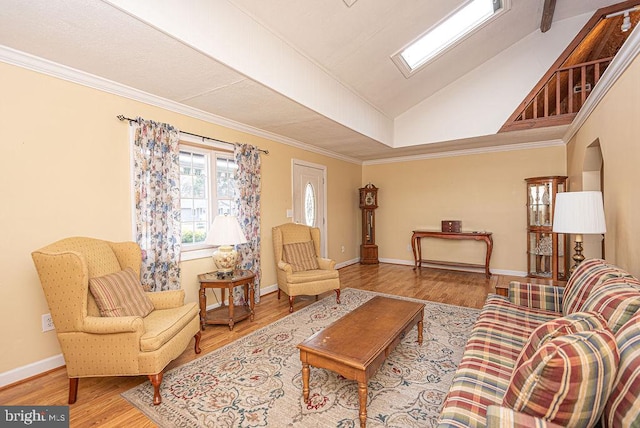 living room with lofted ceiling with skylight, light hardwood / wood-style flooring, and ornamental molding