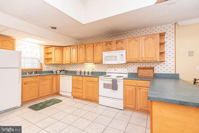 kitchen featuring kitchen peninsula, white appliances, sink, and light tile patterned floors