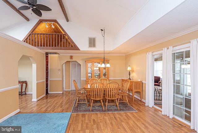 dining space featuring lofted ceiling with beams, crown molding, wood-type flooring, and ceiling fan with notable chandelier