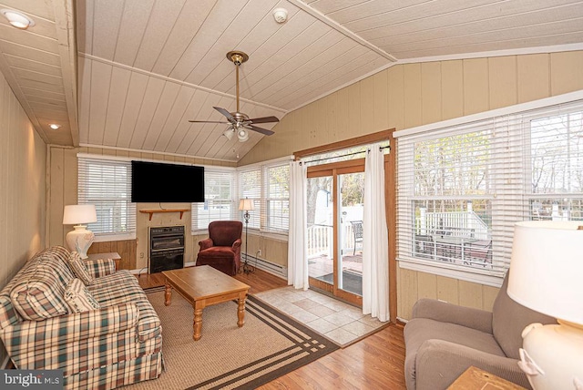 living room with wood walls, lofted ceiling, ceiling fan, light wood-type flooring, and wood ceiling